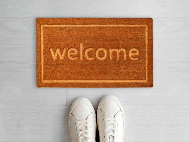 istock Designer Welcome Entry Doormat Placed on White Floor with White Shoes 1453920364