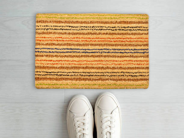 istock Designer Welcome Entry Doormat Placed on White Floor with White Shoes 1453921366