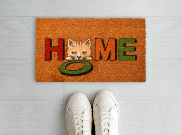 istock Designer Welcome Entry Doormat Placed on White Floor with White Shoes 1453921387