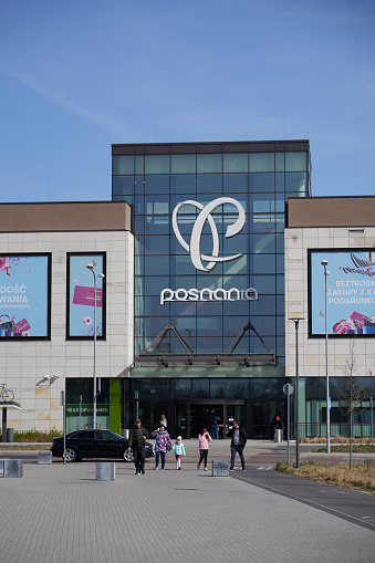 Poznan, Poland – April 02, 2022: A closeup of the Posnania shopping mall building with walking peop