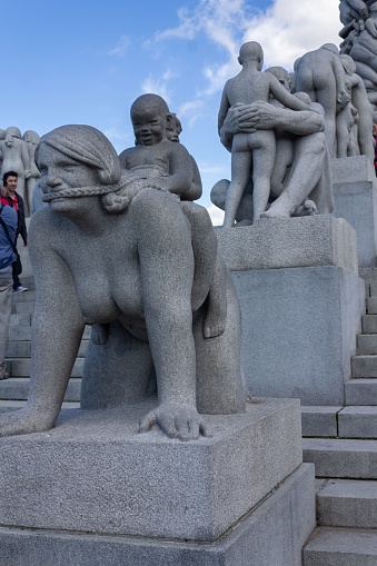 Oslo, Norway – June 06, 2013: The tourists sightseeing the modern sculpture about motherhood in the Vigeland park on a sunny day, Oslo