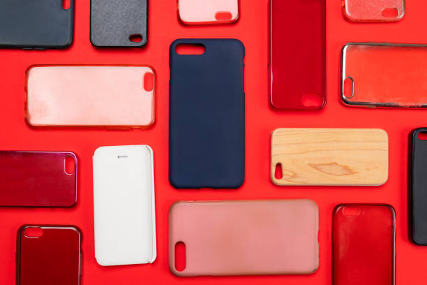 istock Pile of multicolored plastic back covers for mobile phone. Choice of smart phone protector accessories on red background. A lot of silicone phone backs or skins next to each other 1453924417