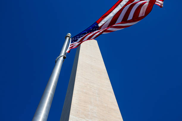 istock Low angle view of American flag under blue sky 1453925422