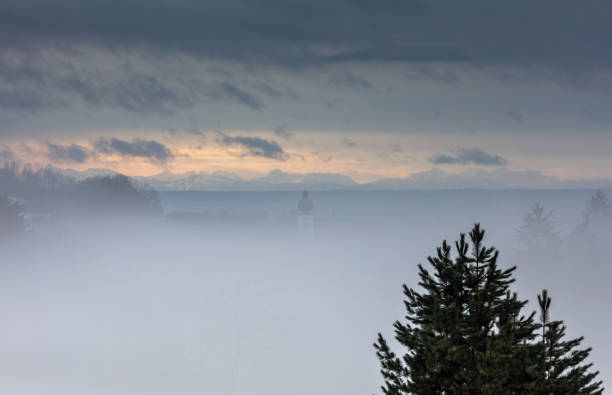 Fog over Grafling Village, a hint of St. Andreas Church in the mist, Lower Bavaria, Germany