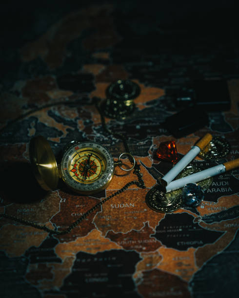 istock Vertical shot of cigarettes and a compass on a world map 1453926621