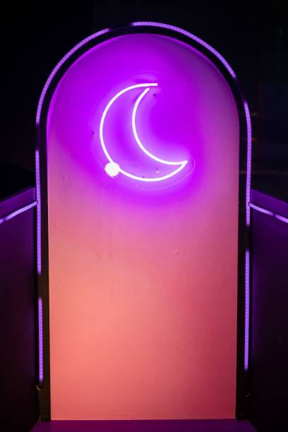 istock Crescent moon-shaped neon symbol on a gradient purple-pink background surrounded by LED lights 1453927778