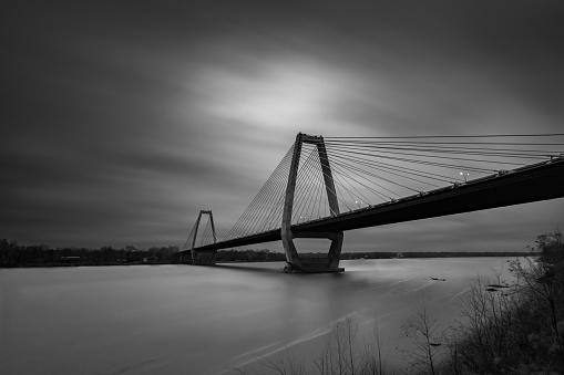A grayscale view of  Lewis and Clark Bridge against cloudy sky in Louisville, Kentucky, United States