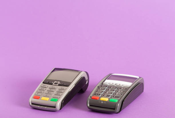 istock Closeup of two electronic payment terminals isolated on light purple background 1453929578