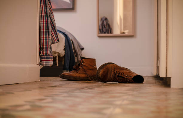 istock Boots on floor and unwashed clothes on bed in bedroom 1453933099