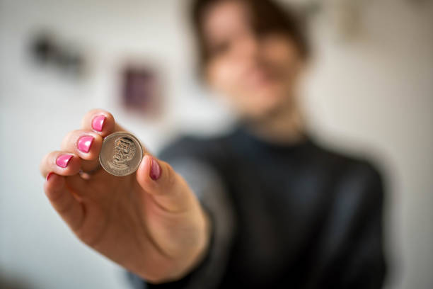 Economic Concept of Silver Color Ukrainian Hryvnia Coin in Woman's Hand with Pink Painted Nails with Picture of Economic Concept of Silver Color Ukrainian Hryvnia Coin in Woman's Hand with Pink Painted Nails with Defocused Background of Her in Her Roo coin collection stock pictures, royalty-free photos & images