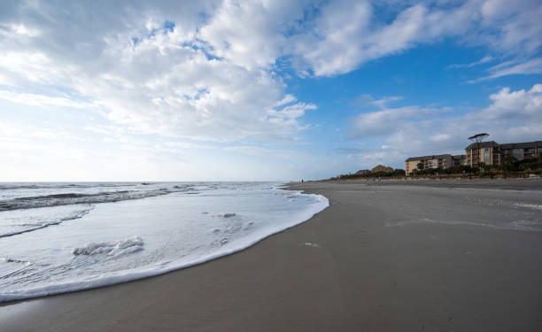 Beautiful shot of the beach in Hilton Head South Carolina hotel under a blue cloudy sky A beautiful shot of the beach in Hilton Head South Carolina hotel under a blue cloudy sky hilton head stock pictures, royalty-free photos & images