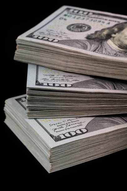 istock Three bundles of 100 american dollar bills on a black background 1453939082