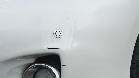 Deep scratches and paint damage on a bumper vehicle. car scratch and dent. accident involving a car crash.