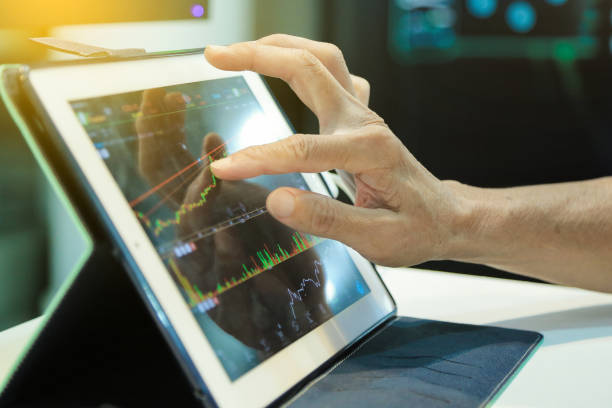 istock Touching stock market graph on a touch screen device 1453941288