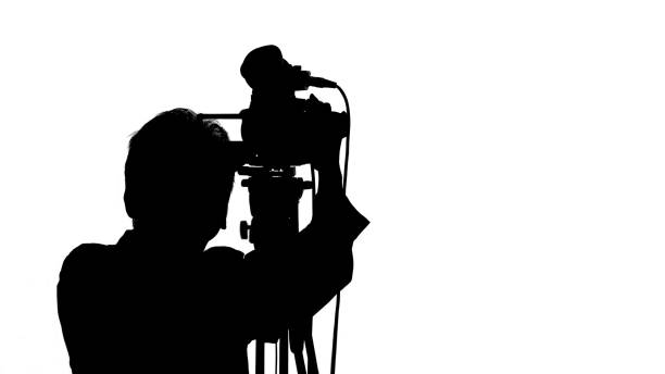 istock Cameraman with video camera. Silhouettes on white background. 1453941364