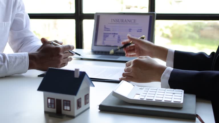 Real estate agent discusses with a buyer about a house purchase agreement, home insurance, lease, mortgage, rental.