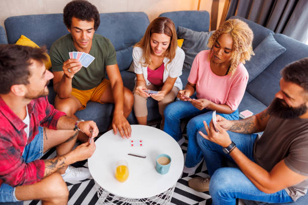 istock Friends having fun playing card games 1453944553