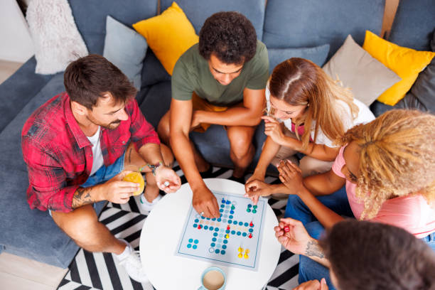 istock Friends having fun playing ludo board game 1453945435