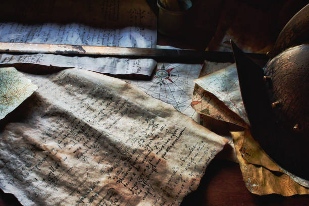 istock An old sword and helmet on the captain's table aboard a pirate ship, with old parchment maps and documents 1453945606