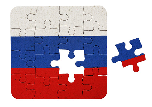 Russian flag printed on a jigsaw puzzle, with one piece not yet placed, representing a problem to be solved.