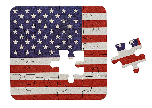 USA flag printed on a jigsaw puzzle, with one piece not yet placed, representing a problem to be solved.