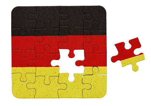 German flag printed on a jigsaw puzzle, with one piece not yet placed, representing a problem to be solved.