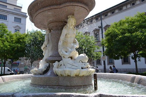 Milan, Italy - June 7, 2015: Panoramic view of the beautiful fountain of the three sirens in white marble in Milan on a sunny summer day.