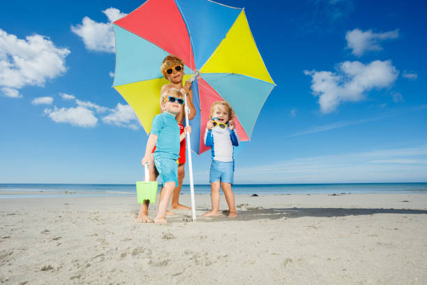 istock Three beautiful children, boys and girl in sunglasses on beach 1453951663