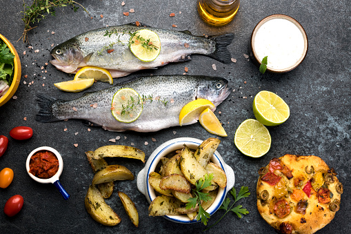 Cooking fish meat with lemon, parsley and garlic . Top View