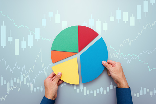 Investor managing portfolio. Pie chart and candlestick charts.
