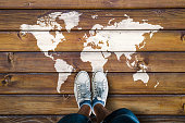 World map on a wooden floor and man in shoes
