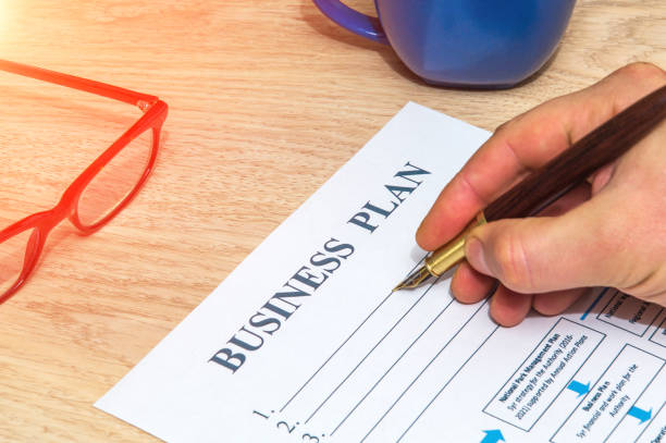istock Person fills out a business plan form before starting successful strategy 1453958665