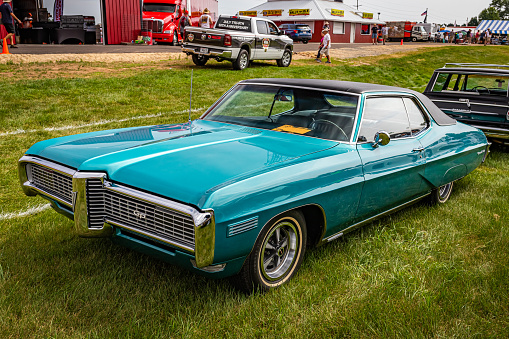 Iola, WI - July 07, 2022: High perspective front corner view of a 1968 Pontiac Grand Prix Coupe at a local car show.
