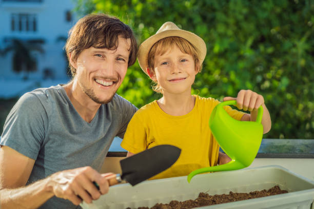 istock Dad and son is doing gardening on his balcony. Natural development for children 1453962156