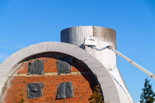 istock Coating the building structure with white lime. Painting a concrete pipe. Construction work at height. 1453962564