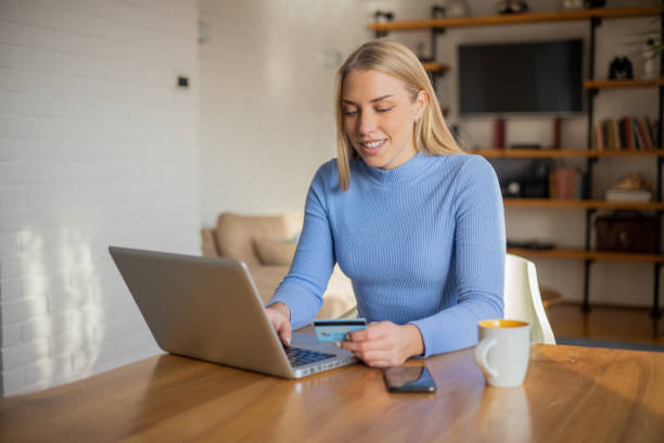 istock Cheerful  young woman doing online shopping 1453964014