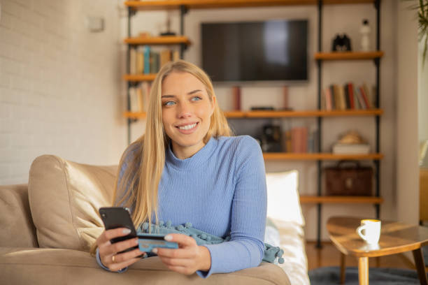 istock Cheerful  young woman doing online shopping 1453964083