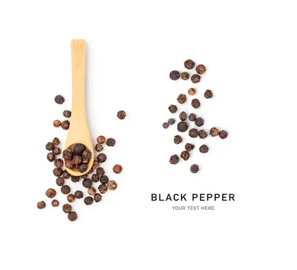 Peppercorns in bamboo wooden spoon creative layout. Black pepper seeds isolated on white background. Flat lay. Design element. Healthy eating and dieting food concept