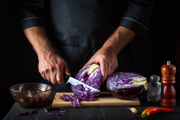 istock A professional chef cuts red cabbage with a knife. Cooking vegetable salad in the restaurant kitchen. Vegetable diet idea. 1453965474
