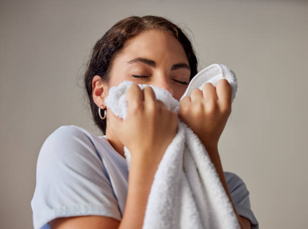 istock Woman smelling a clean towel after doing laundry at her home, hotel or resort while spring cleaning. Housekeeping, maid or housewife doing washing for maintenance, hygiene and fresh fabrics or cloth. 1453967894