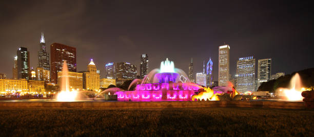 panoramic shot of buckingham fountain in grant park at night lit by colorful lights, chicago, usa - chicago fountain skyline night imagens e fotografias de stock