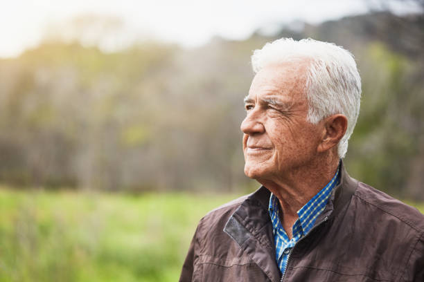 istock Thoughtful senior man looks into copy space as he stands outdoors in nature 1453968261