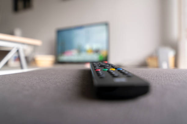 Television remote in living room with background blur.
