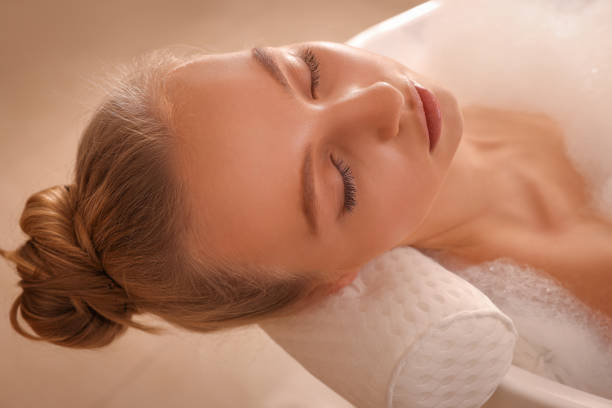 istock Young woman using pillow while enjoying bubble bath indoors, closeup 1453969472