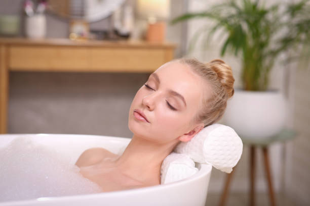 istock Young woman using pillow while enjoying bubble bath indoors 1453969510