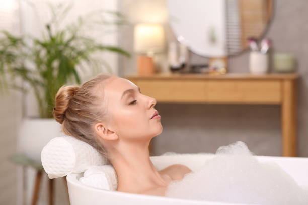 istock Young woman using pillow while enjoying bubble bath indoors 1453969516