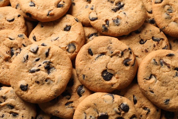 istock Many delicious chocolate chip cookies as background, top view 1453969602