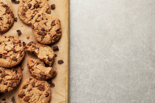 istock Delicious chocolate chip cookies on parchment paper, top view. Space for text 1453970212