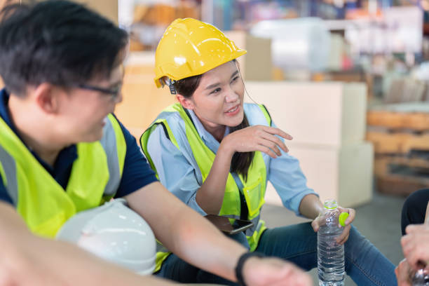 istock Staff in large storage warehouse together sit back relax cheers drinking bottle 1453970580