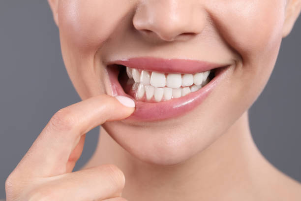 young woman showing healthy gums on grey background, closeup - gums imagens e fotografias de stock